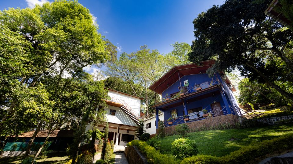 Vista de las cabañas en Villa Shalom, rodeadas de árboles y un cielo azul, en Santa Rosa de Copán, Honduras.