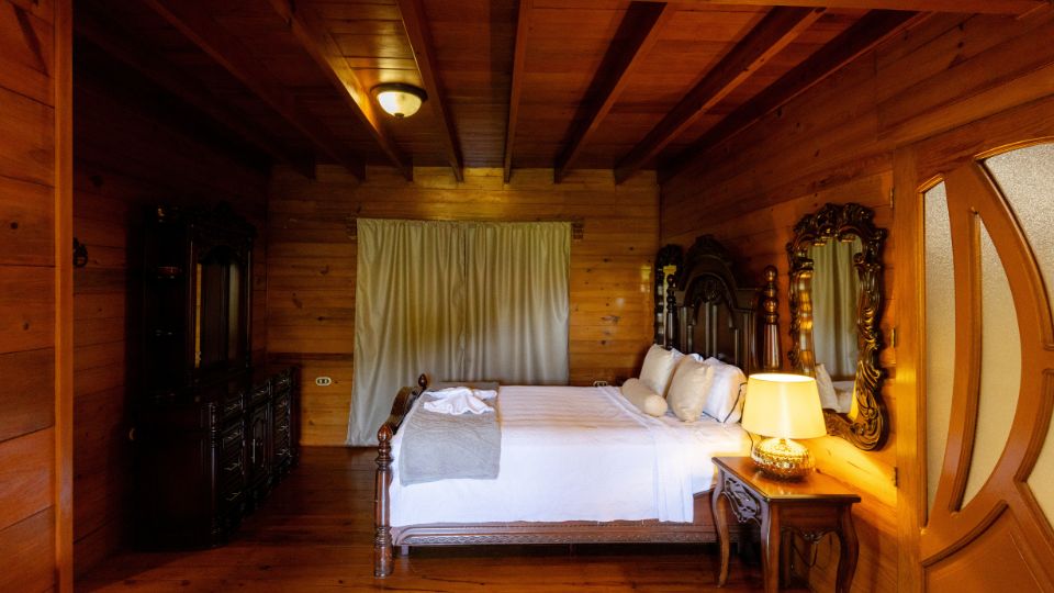 Habitación acogedora en Villa Shalom, con cama grande, decoración de madera y luz cálida, ideal para una estancia relajante.