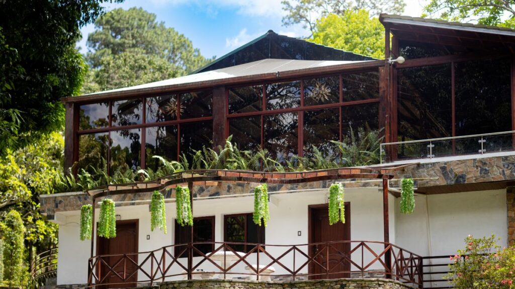 Vista exterior de las instalaciones de Villa Shalom en Santa Rosa de Copán, Honduras, con vegetación y balcones.