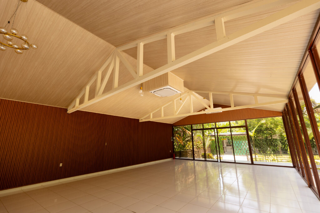 Salón amplio y luminoso en Villa Shalom, con techos altos y ventanales que ofrecen vista al jardín exterior.