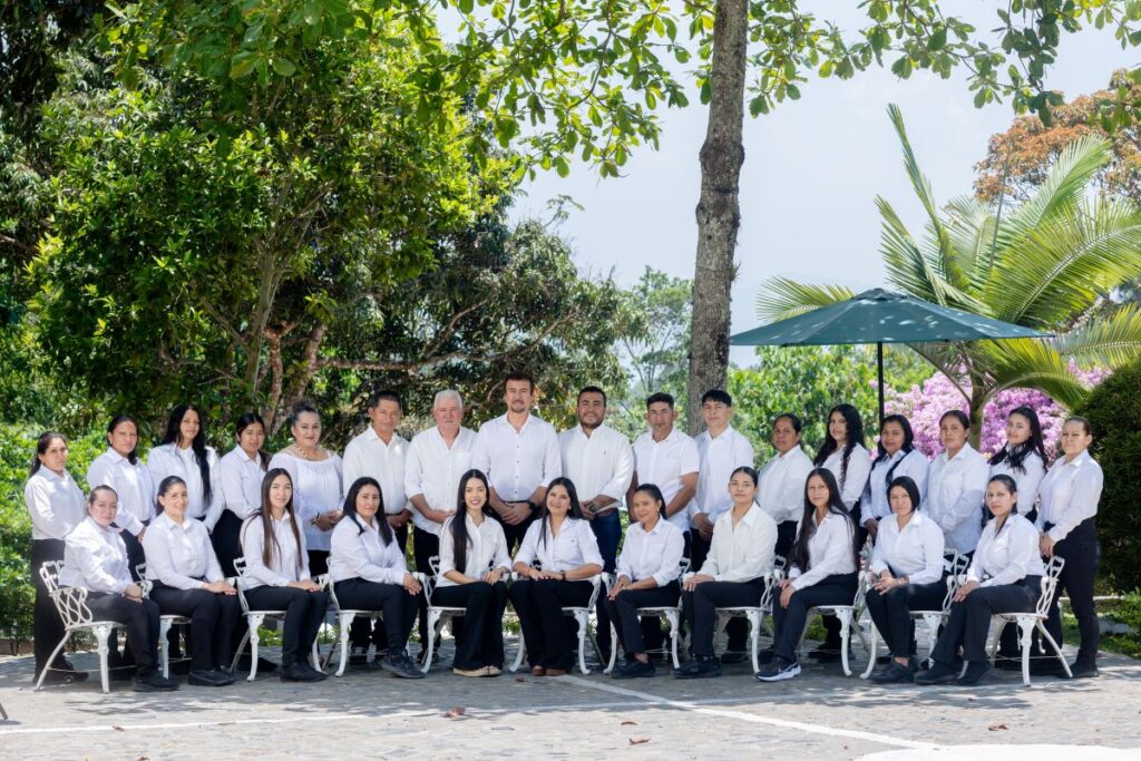 Equipo de trabajo de Villa Shalom en Santa Rosa de Copán, Honduras, posando al aire libre con camisetas blancas y pantalones oscuros.
