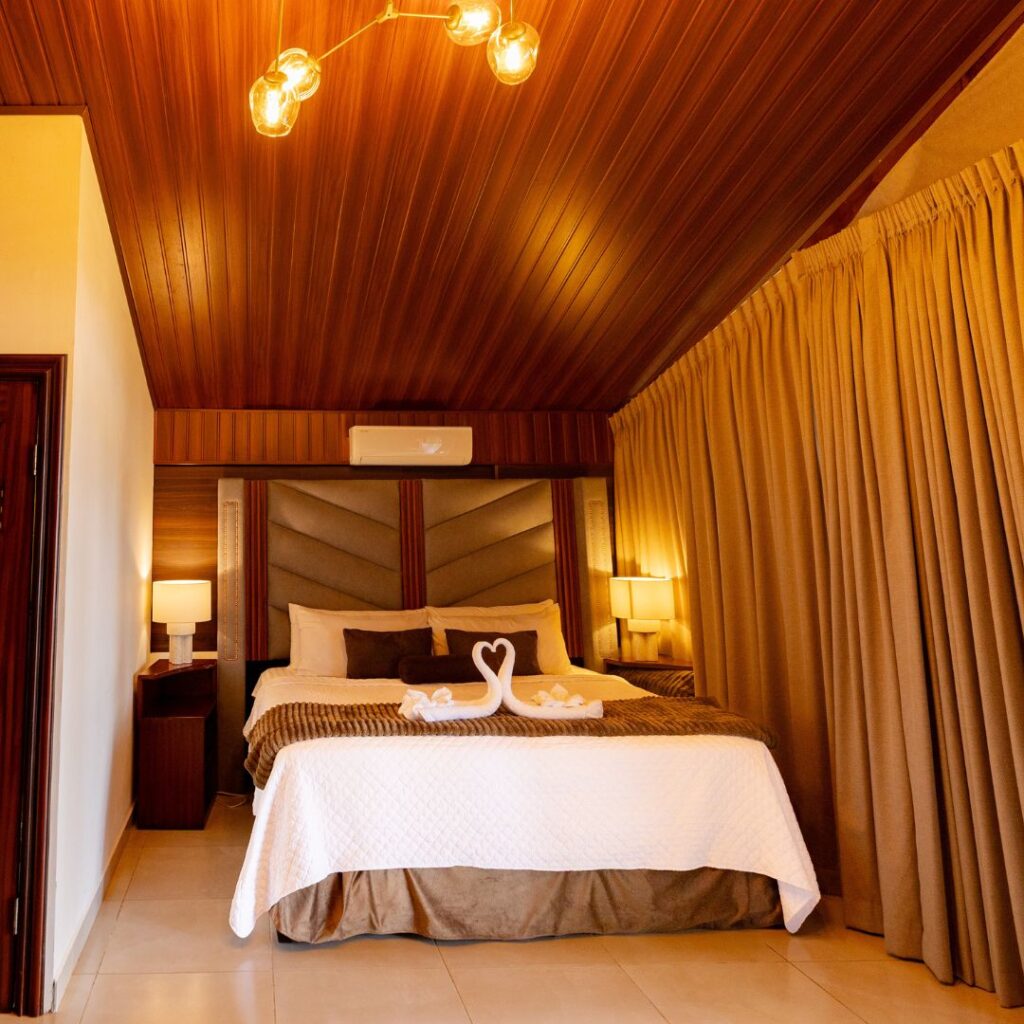 Habitación acogedora en Villa Shalom, con cama matrimonial, cortinas suaves y luz cálida, ideal para una estancia romántica en Santa Rosa de Copán.